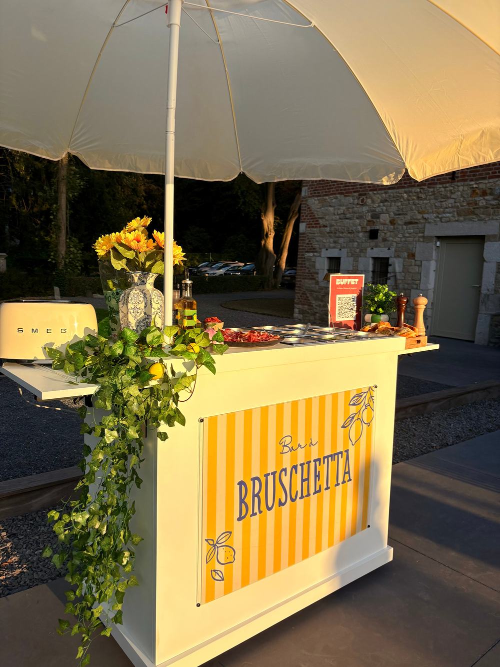 L'aubette mobile habillée en bar à bruschetta, rayures jaunes, sous un parasol