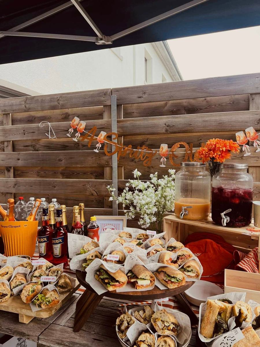 Buffet installé en terrasse avec bocaux de boissons et sandwiches